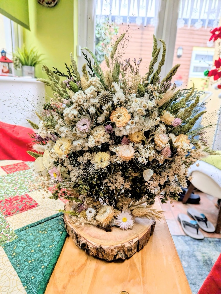 A dried-flower centrepiece on a log slice