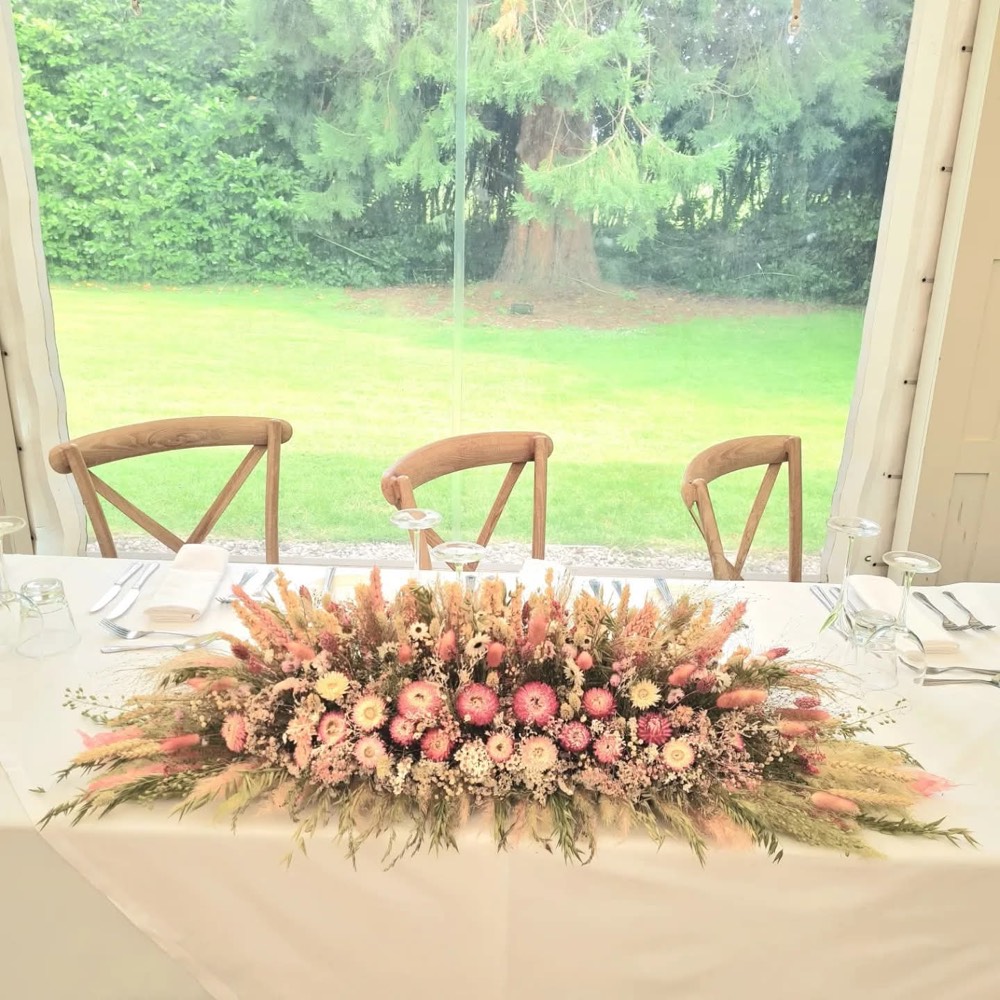 A dried-flower top-table centrepiece by a window